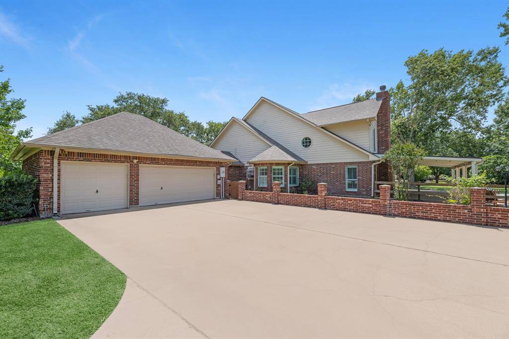 The three car garage includes a separate single bay for added versatility. With ample parking and a striking brick wall lining the drive, this property is perfect for hosting guests or simply enjoying the extra space.