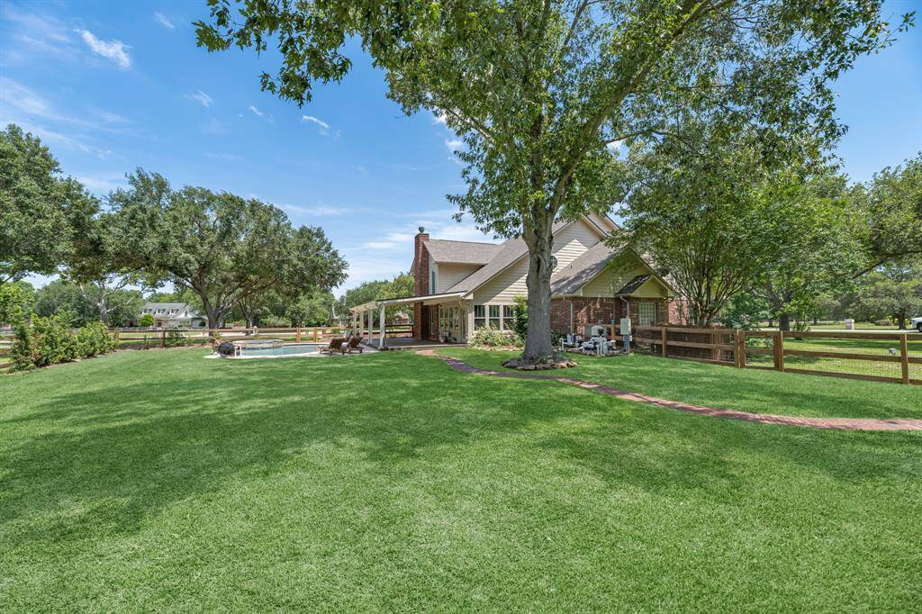 Follow the charming brick walkway leading you to a serene garden area—an inviting space to relax and enjoy nature’s beauty.