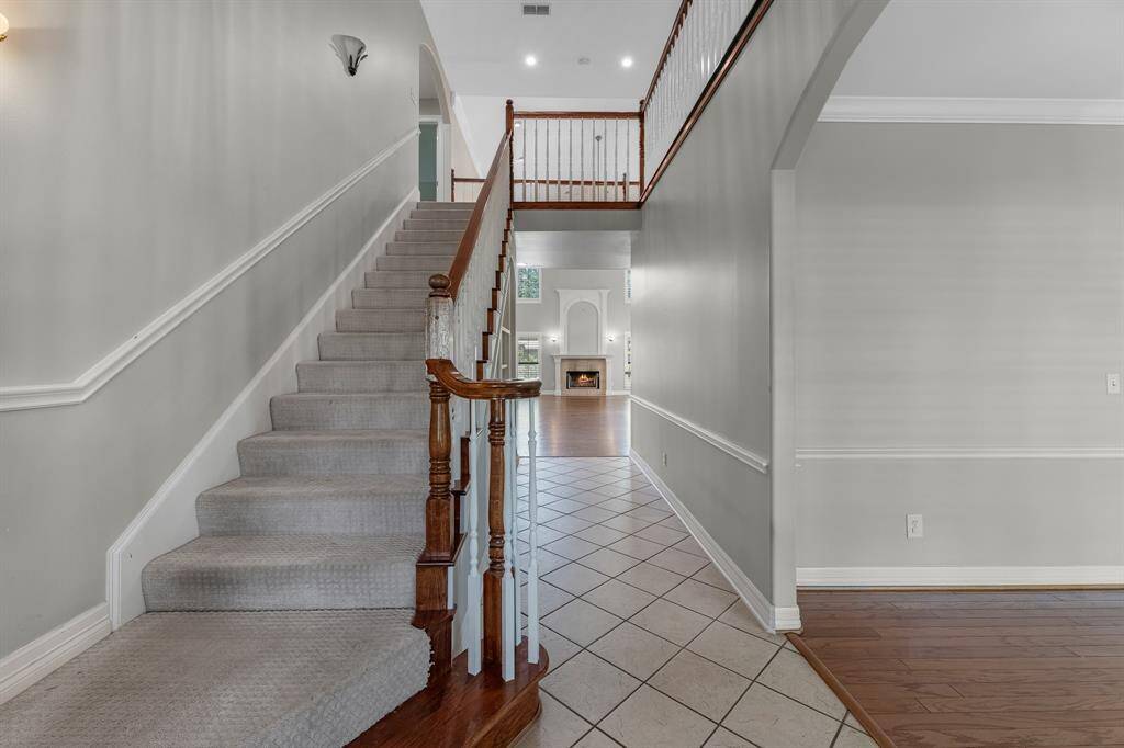 Step inside through charming double front doors and take in the inviting layout—stairs to the left, formal dining to the right, and a seamless flow straight ahead into the spacious family room.