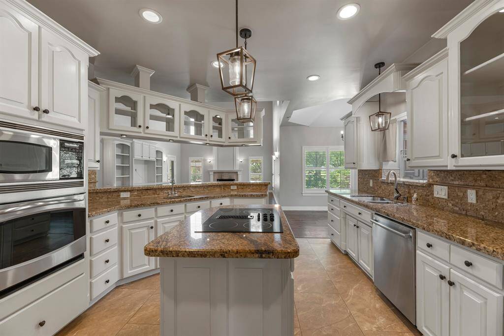 At the heart of the home, this beautifully designed kitchen offers granite countertops, crisp white cabinetry, and ample storage throughout. Recessed lighting enhances the open layout—perfectly suited for everyday living and effortless entertaining.