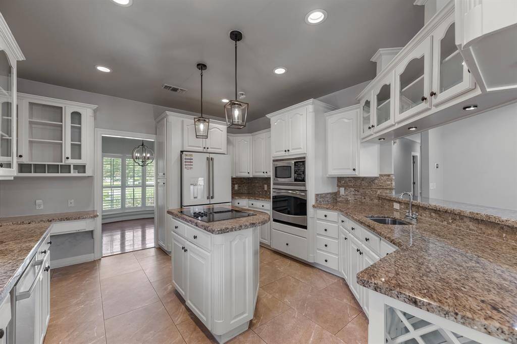 Additional kitchen highlights include a built-in oven with a microwave above and a rare yet practical feature—two sinks, including a dedicated prep sink for added convenience during meal prep and entertaining.