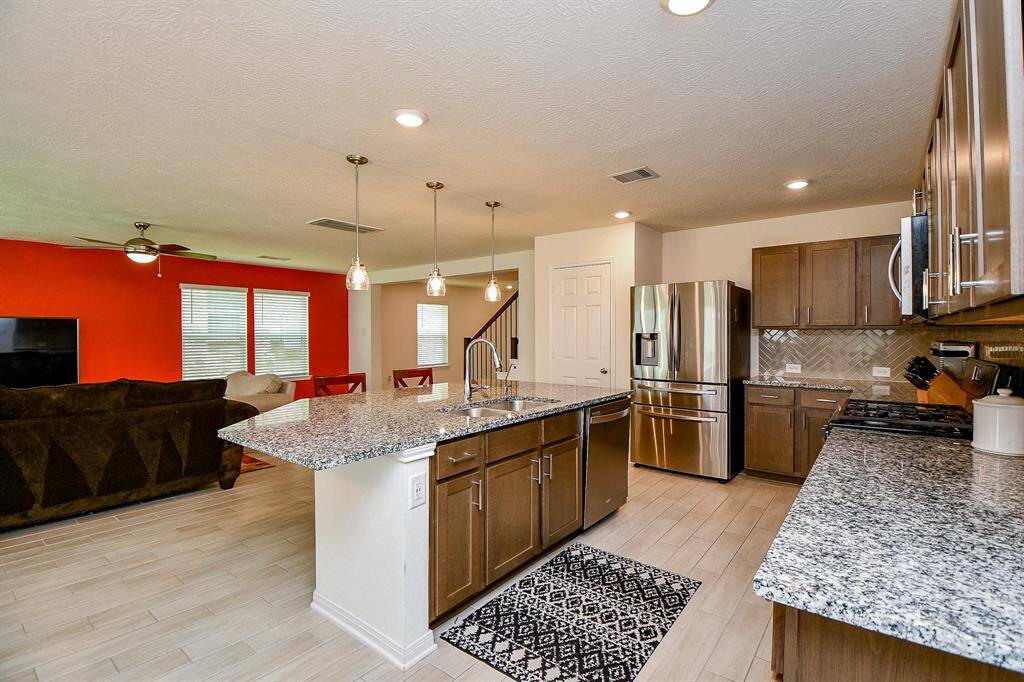 This large, well-designed space flows seamlessly from the breakfast area into the kitchen and living room, creating a bright and inviting setting that looks both spacious and stylish.