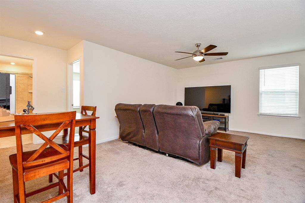 This view of the game room showcases its generous size and open layout, providing a versatile space for activities or relaxation. It also serves as a central hub, leading seamlessly to the secondary bedrooms for easy access and flow. This space offers plenty of possibilities