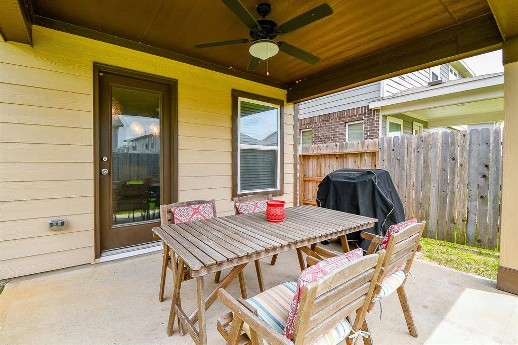Just off the breakfast room, the covered patio offers a comfortable outdoor retreat with a ceiling fan for added breeze. It's the perfect spot for grilling, relaxing, or entertaining while enjoying views of the spacious backyard.