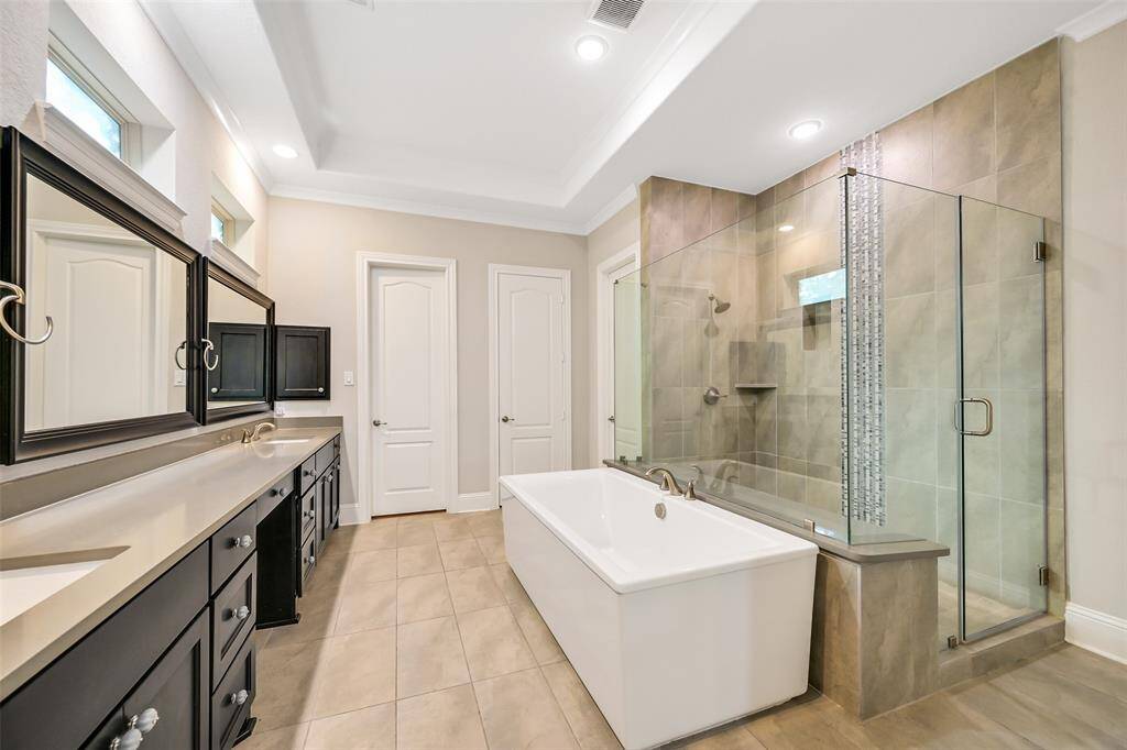 The primary bath includes double sinks, seated vanity, large soaking tub and walk-in shower. There is a huge walk-in closet with island storage.