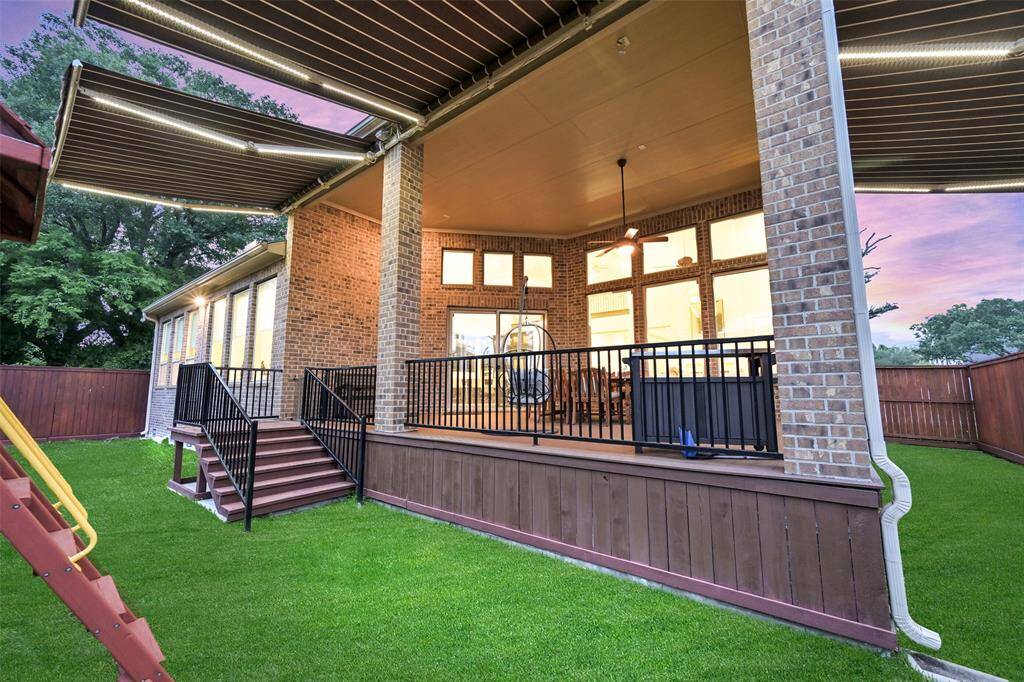 Another view of the back yard looking back at the covered patio with retractable awnings.