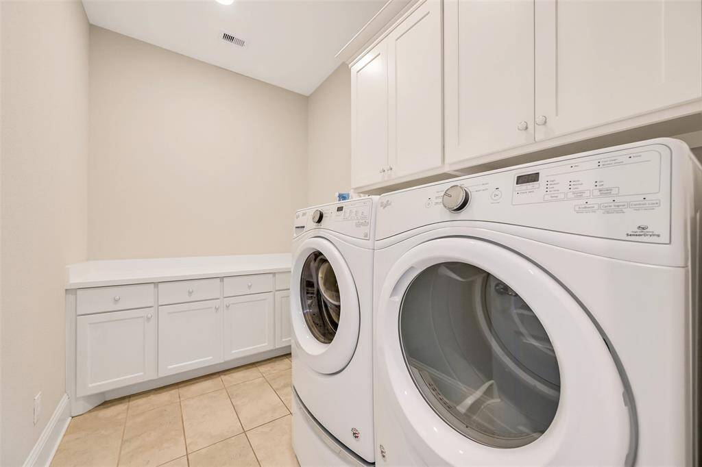 The large utility room has ample storage and counterspace for folding. Just outside the utility room is the lockers and drop zone next to the garage entry.