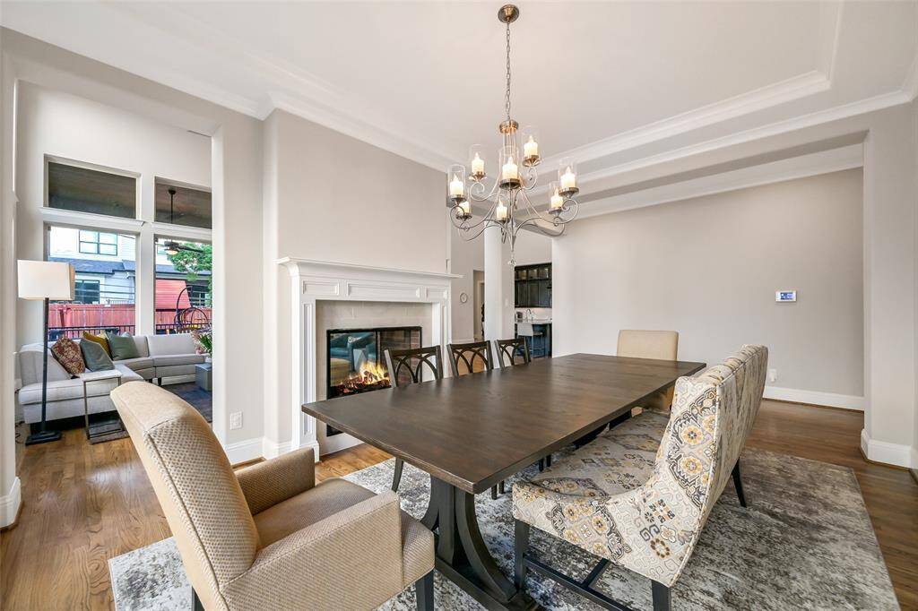 The formal dining room flows seamlessly from both sides of the fireplace to the main family room and kitchen.