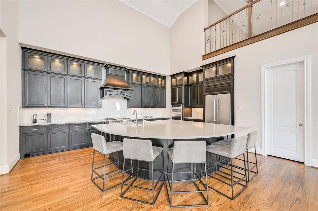 The large island kitchen offers storage and display cabinets, six burner gas range, built-in microwave and convection oven as well as a large walk-in pantry.
