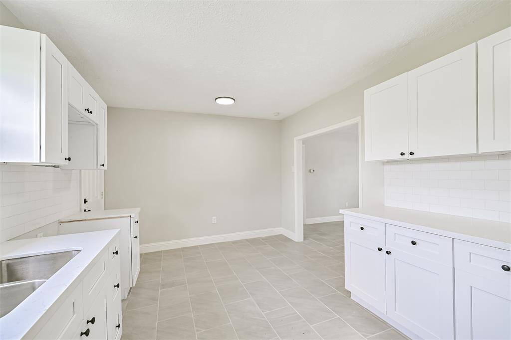 Opposite view of the kitchen reveals seamless access to the living area, making this space perfect for entertaining or everyday family living.