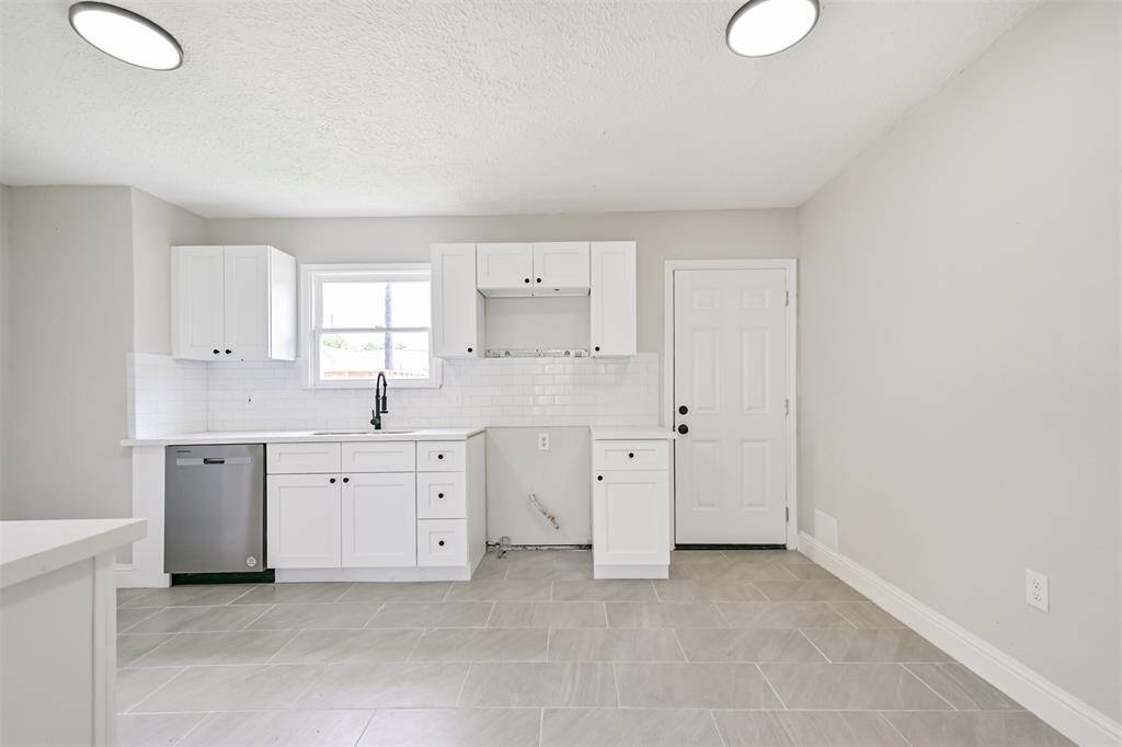 Another angle of the kitchen showcasing multiple cabinetry options for storage and an open space beneath the hood for your preferred range setup.