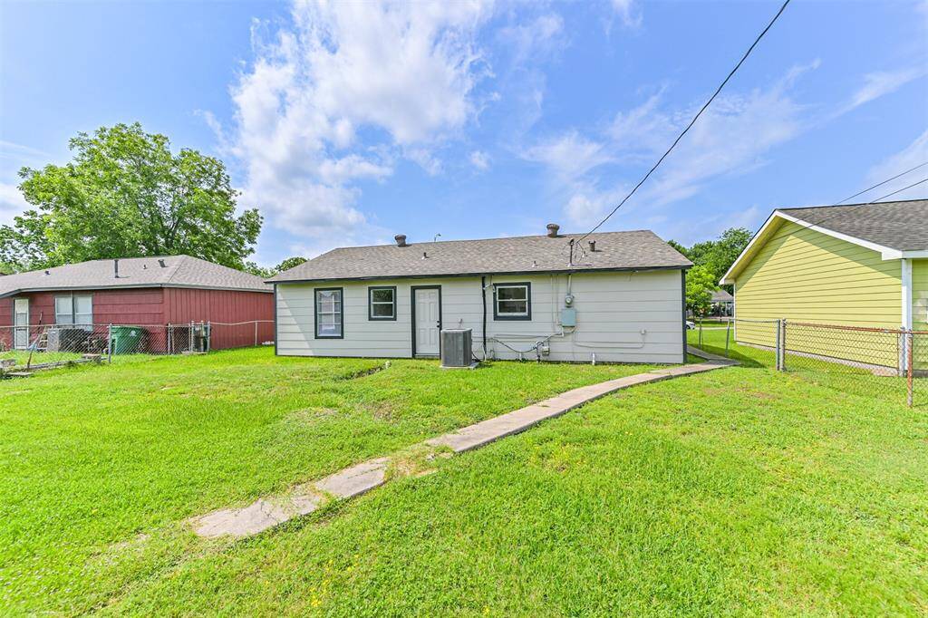 An alternate angle showcases the lush grass, well-maintained siding, and a wide, open yard perfect for future customization.