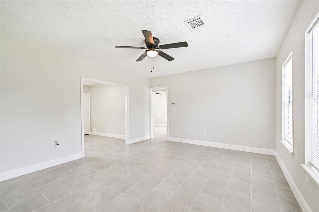 This spacious living room boasts a neutral palette and multiple entry points that create great flow between living areas.