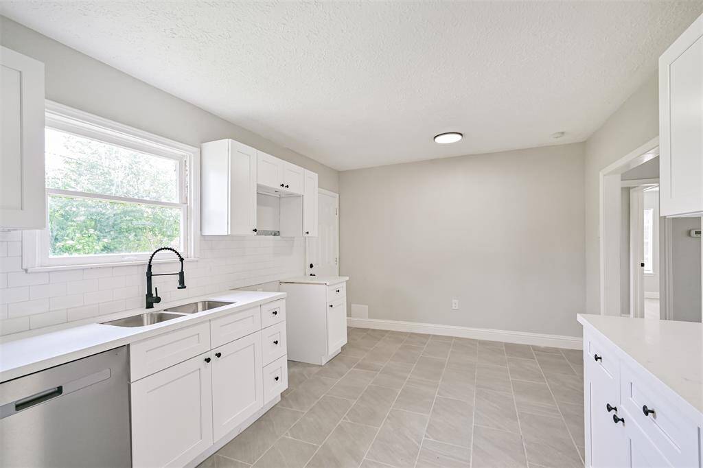 This kitchen provides ample space for a breakfast area. Enjoy quick access to the backyard via the craftsman style door.