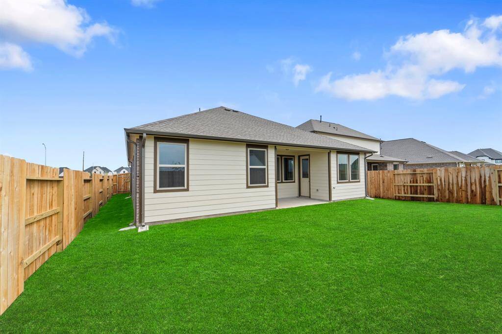 The covered patio is generously sized, providing ample space for various outdoor activities.