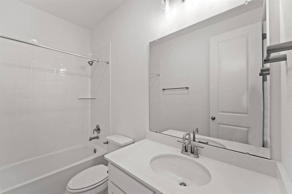 The secondary bath features tile flooring, white cabinetry and light countertops and a shower/tub combo. Perfect for accommodating any visiting family and friends.
