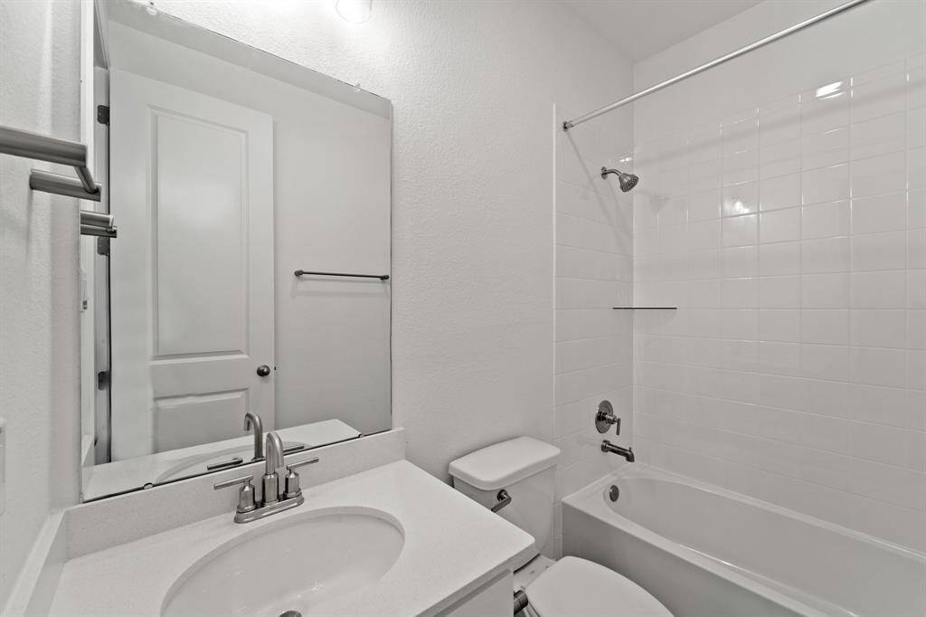The secondary bath features tile flooring, white cabinetry and light countertops and a shower/tub combo. Perfect for accommodating any visiting family and friends.