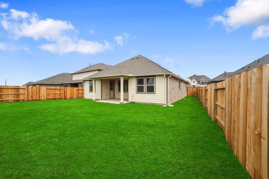The covered patio is generously sized, providing ample space for various outdoor activities.