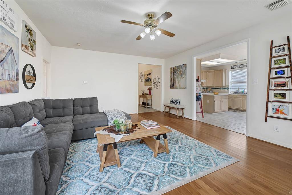 Bright and welcoming living area featuring bamboo flooring and an open layout perfect for gatherings. Flows seamlessly into the kitchen and entryway, creating a connected and functional space.
