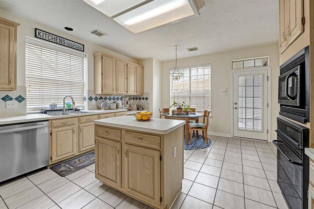 Light-filled kitchen with generous cabinet space, center island, and charming diamond tile backsplash. Enjoy casual meals in the bright breakfast nook with relaxing backyard views.