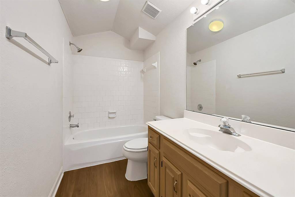 Clean and simple guest bathroom on 2nd floor with classic white tile surround and a tub/shower combo. Features newly installed wood-look flooring and a vanity with great counter space.