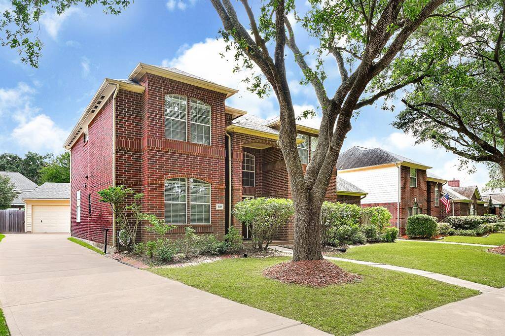 Charming two-story red brick home with well-manicured landscaping and a long private driveway. Mature trees provide shade and enhance the curb appeal.