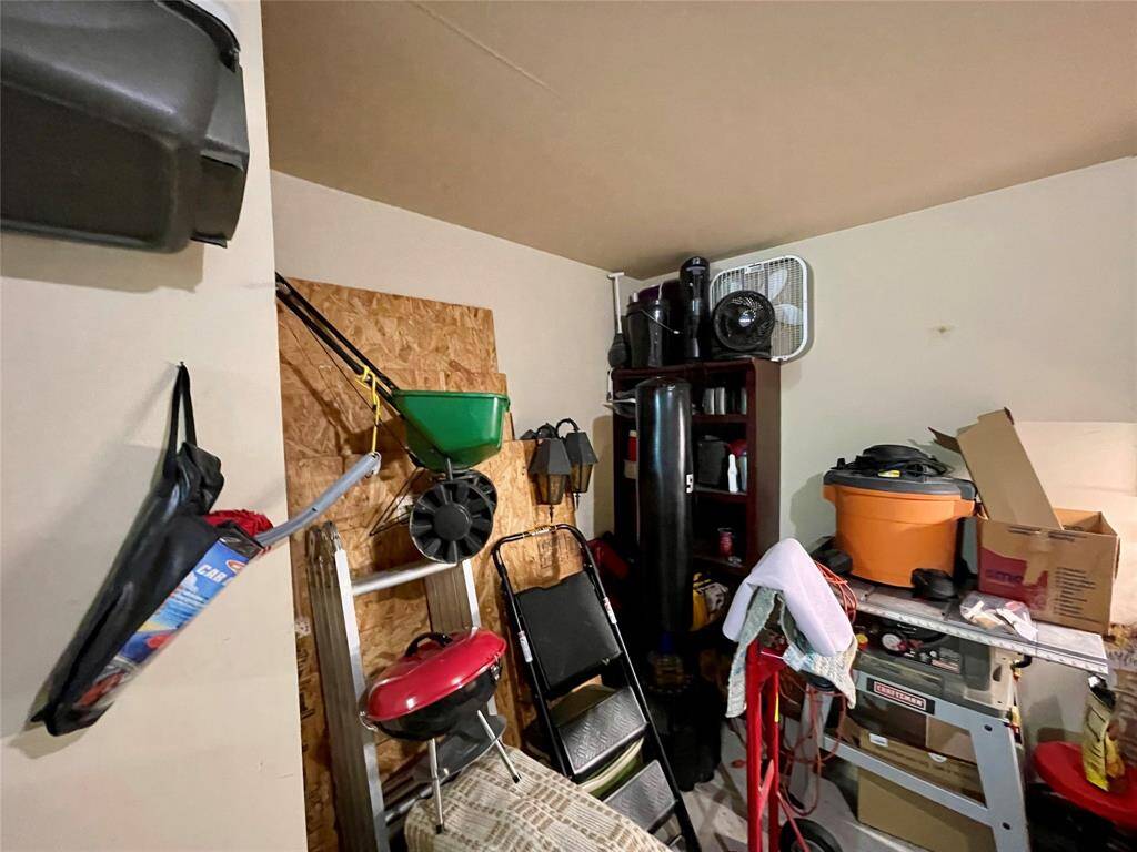 Storage nook in garage with hurricane wood to cover windows.