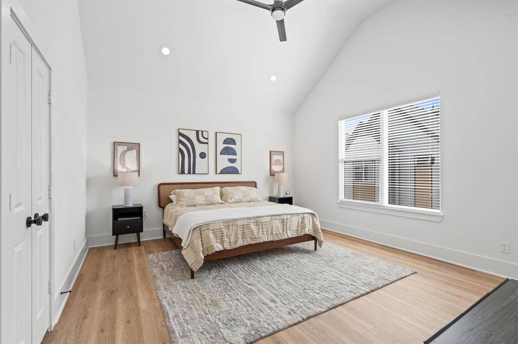 Experience rest and tranquility in this primary bedroom, adorned with a vaulted ceiling, which is complemented by a ceiling fan and recessed lighting for added comfort. Oversized windows flood the space with natural light, accentuating the airy ambiance, while the absence of carpet provides modern elegance and easy maintenance! *All interior photos are from the model home: 5216 Pine Tree*