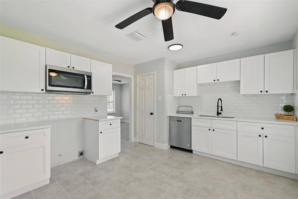 Spacious kitchen boasts white shaker-style cabinetry, modern granite countertops, and a white subway tile backsplash that adds just the right touch of character.