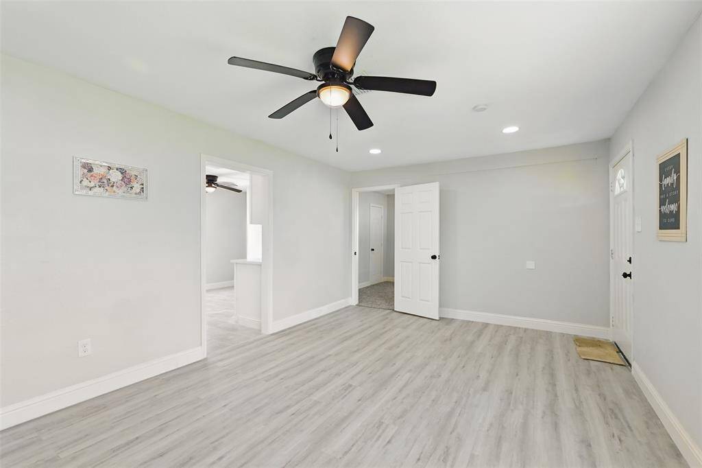 This spacious living room boasts a neutral palette, recessed lighting, and multiple entry points that create great flow between living areas.