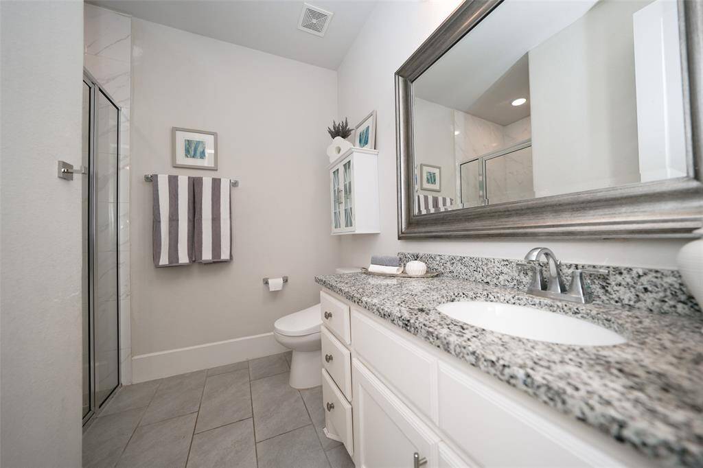 Chic ensuite guest bath featuring a shower and ample counter space.