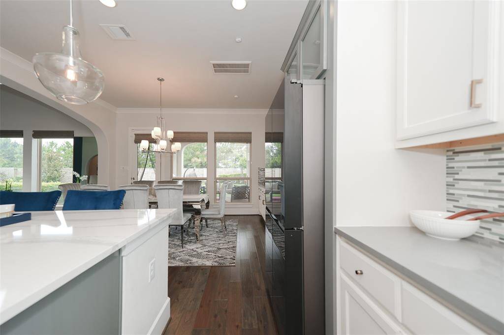 The kitchen boasts a versatile butler’s pantry, perfect for a coffee bar or bar setup, seamlessly connecting to the dining room for effortless entertaining.