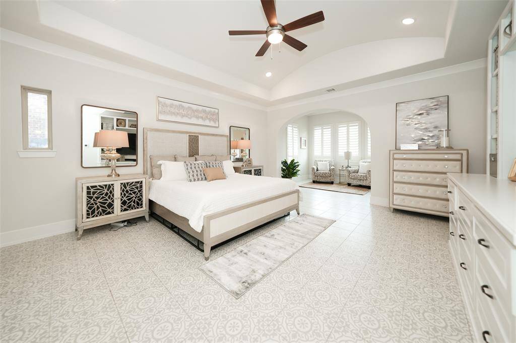Discover the stunning primary suite, featuring abundant natural light, elegant decorative tile floors, a custom entertainment wall, and a spacious sitting area. This versatile space is ready to accommodate your dream vision.
