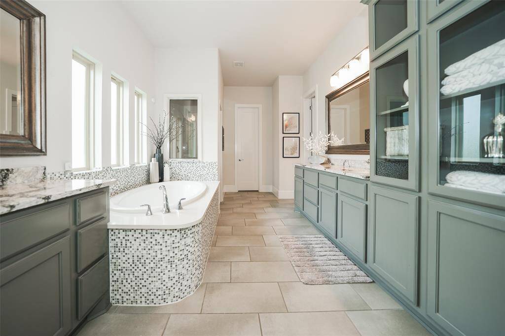 Experience ultimate convenience in the primary bathroom with ample storage, a large soaking tub, separate shower, and a linen closet. It seamlessly connects to the closet and laundry room for effortless living.