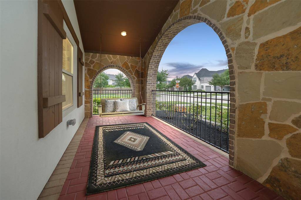 This inviting front porch offers ample space for your favorite patio furniture. Unwind on the swing with a coffee and enjoy the serene surroundings.