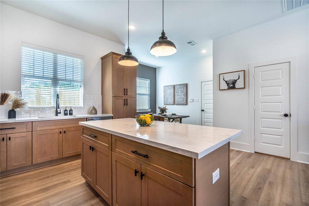 Wood-tone cabinets in the kitchen exude warmth and elegance, offering ample storage while complementing the overall aesthetic of the space.