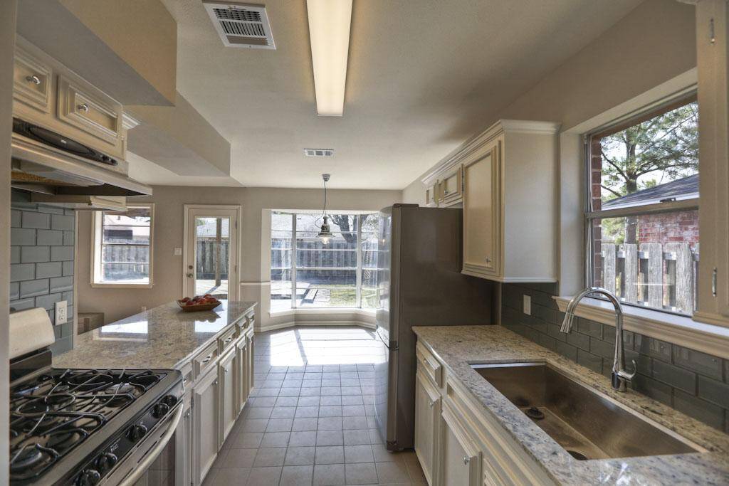 Range, chrome plumbing fixtures and deep stainless sink adds to the nicely appointed kitchen.
