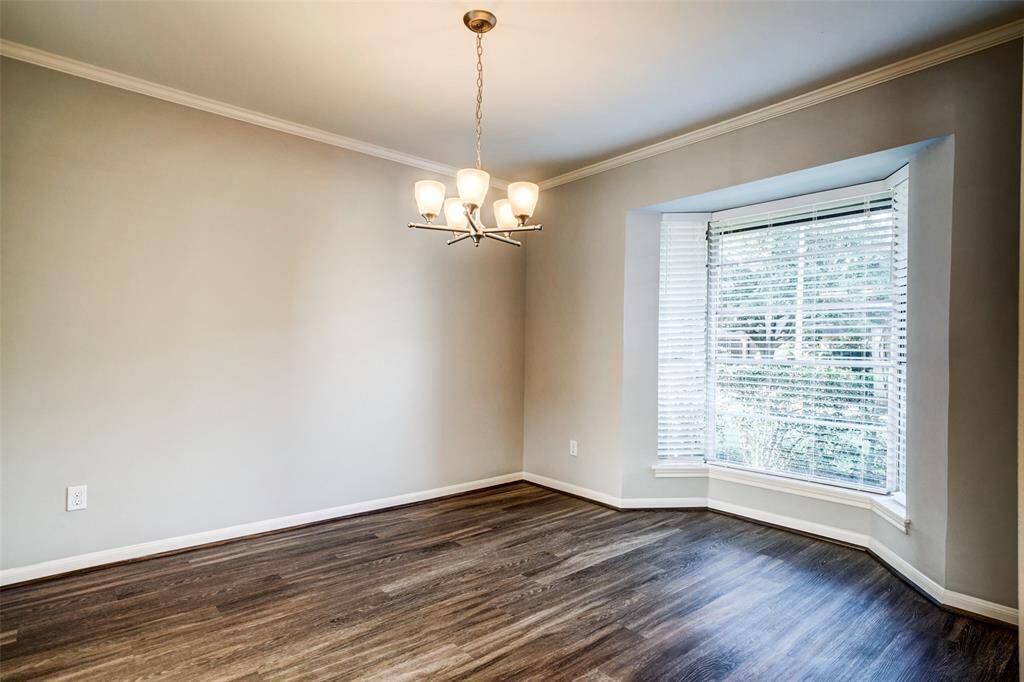 Formal dining room features a bay window and stylish lighting.