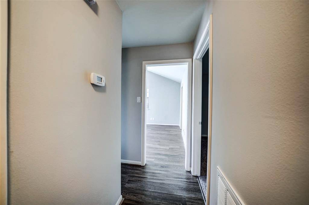 Hallway leads to the 3 bedrooms, attached garage and both bathrooms.