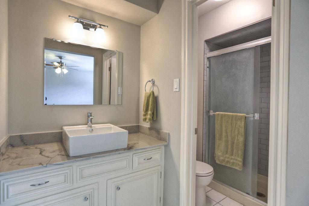 Primary bath features granite countertops, tile, sinks, plumbing and lighting fixtures.