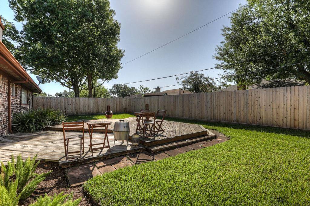 Spacious backyard features a tiered deck and recent fence.
