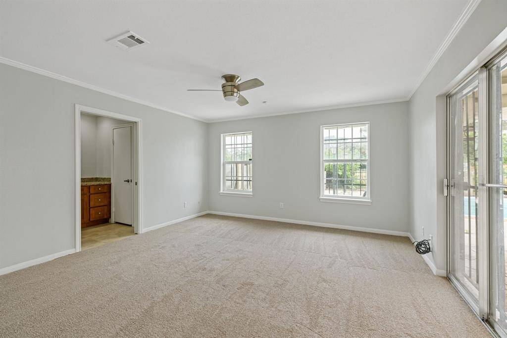 Primary bedroom tucked in the back left corner of the home. With a nice walk in closet, primary bath AND direct access to the backyard and pool area.