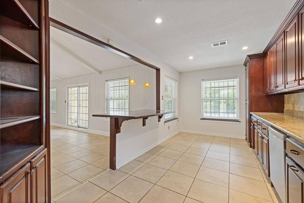Kitchen is large enough for a table near the window and bar stools.