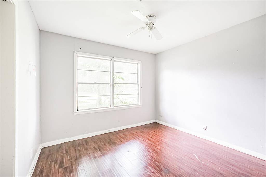 This secondary bedroom features large windows and durable flooring—easy to refresh with paint and lighting. Ideal as a guest room, home office, or flex space.