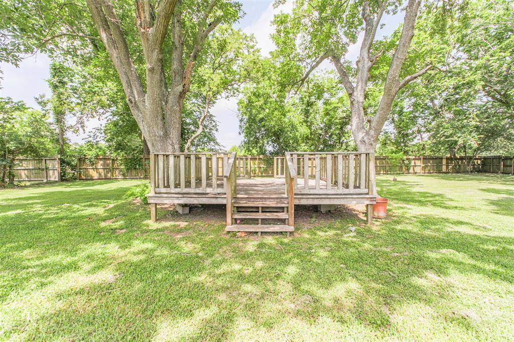 This deck acts as the perfect foundation for an outdoor entertainment hub. Redesigned with cozy string lights and lounge seating, this space can serve as a comfortable backdrop for weekend BBQs under the canopy of mature trees.