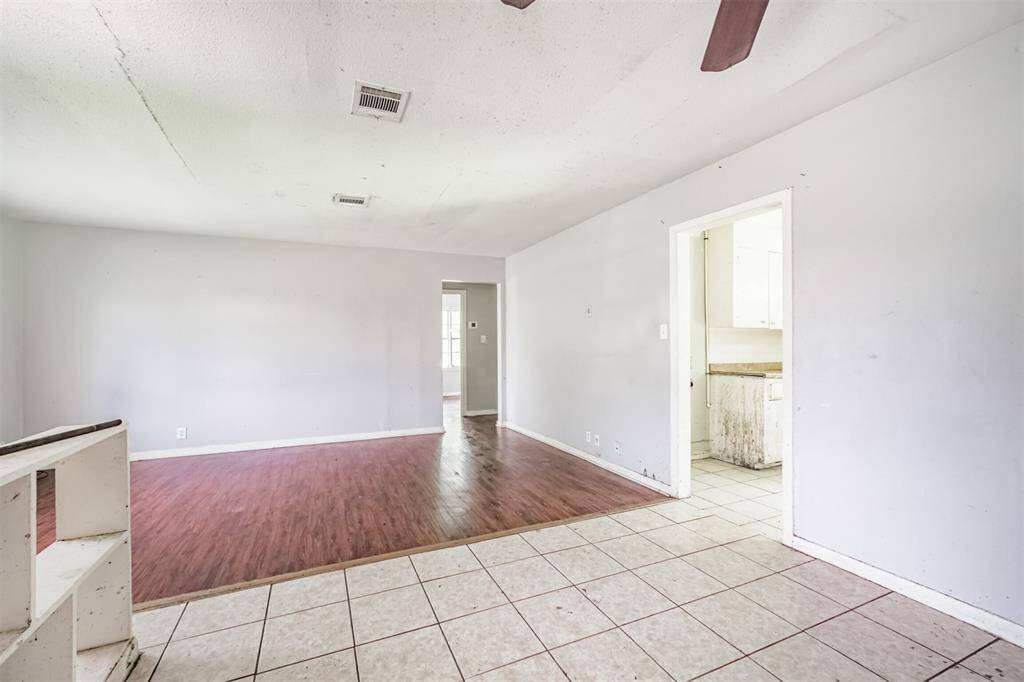 A flexible living area opens directly into the kitchen, creating a seamless space for entertaining with updated flooring and a neutral color palette.
