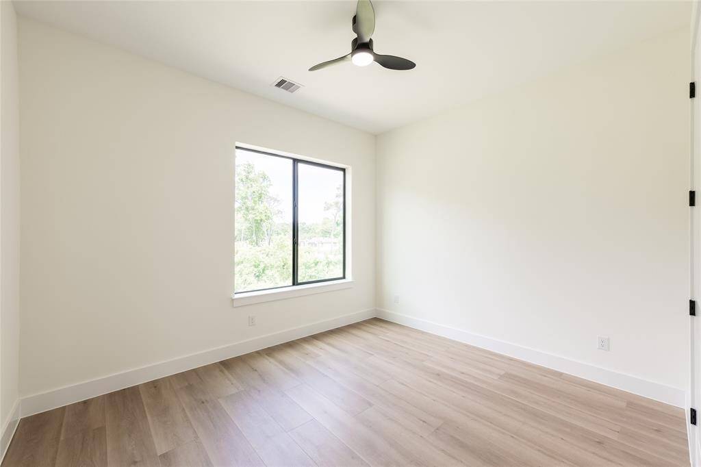 One of the generously sized secondary bedrooms, offering plenty of natural light and versatile space for relaxing or working.