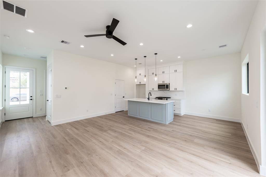 View facing the kitchen with a clear line of sight to the front door, showcasing the home's welcoming entry and seamless layout.