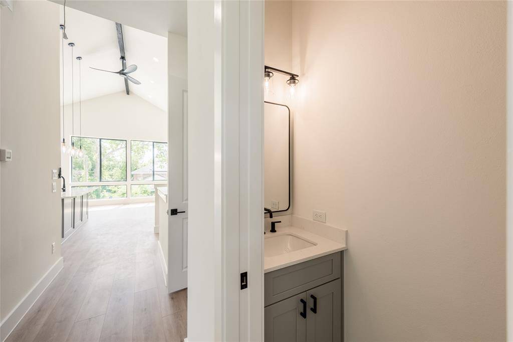 "Hallway leading to a stylish half bath, thoughtfully designed for guests’ convenience and privacy.