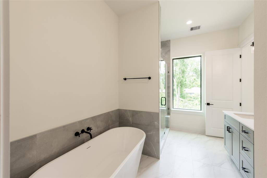 Luxurious primary bathroom featuring a freestanding soaking tub, creating a serene and spa-like retreat.